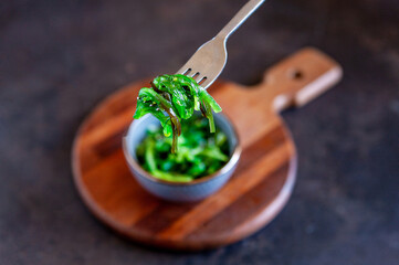 Sea kelp in the bowl with fork on wooden kitchen board