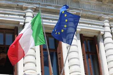 Italian and European flags blowing in the wind during the international meeting of heads of state