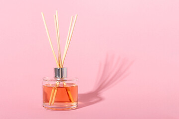 Obraz na płótnie Canvas reed diffuser bottle on a beige background. Incense sticks for the home with a floral scent. The concept of eco-friendly fragrance for the home