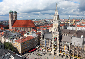 Fototapeta na wymiar double bell tower of the Cathedral and the tall clock tower of the new town hall in Munich in Germany seen from above