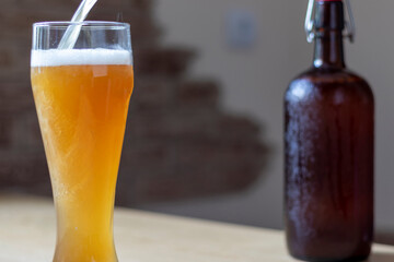 Pouring beer into a glass pint placed on a tree