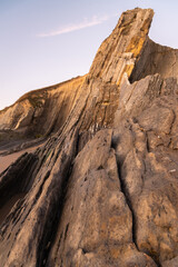 The spectacular rock formations on the shore of La Arnía beach at sunrise, Costa Quebrada, Cantabria, Spain