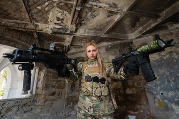 Fototapeta premium Caucasian woman in army uniform holding two machine guns. 