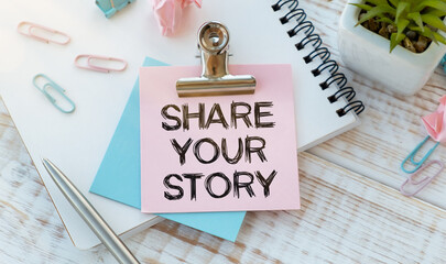 Business concept - Top view notebook writing Share Your Story