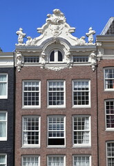 Fototapeta na wymiar Amsterdam Prinsengracht Canal House Facade with Sculpted Roof Detail, Netherlands
