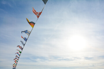 Flags from several countries against a blue sky