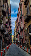 Fototapeta na wymiar Walking in the narrow streets of Naples, Campania, Italy, Europe. Narrow alleyway in the old town of Naples. Area belongs to a UNESCO World Heritage site as part of the historic city center of Naples