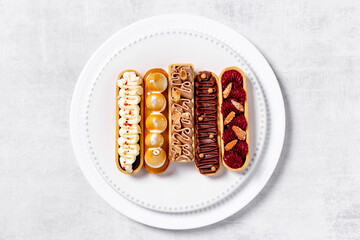 Flatlay of color eclairs with pistachio raspberries and chocolate