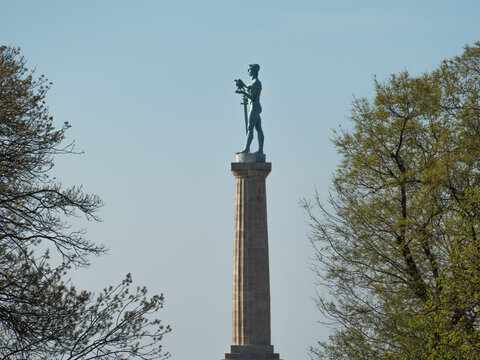 Tall Pobednik monument in Belgrade Fortress from the frame of the trees in Serbia