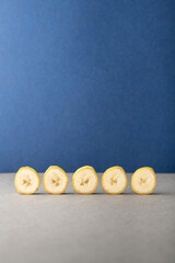 Banana slices on color background