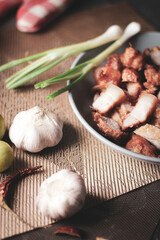 Fried Pork Belly with Fish Sauce Served on a Gray plate on a black wooden floor.