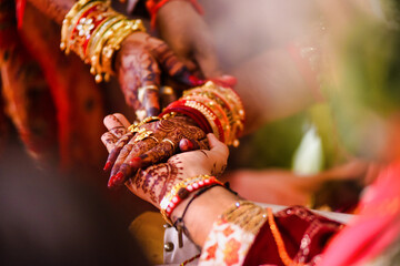 Closeup of hands with henna tattoos during an Indian traditional wedding ceremony, kanyadan ritual