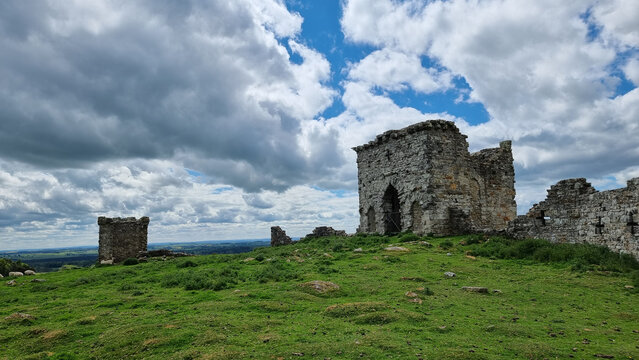 Beautiful shot of a Rothley Castle with a green grass field and a blue sky with clouds