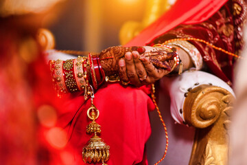 Closeup of hands with henna tattoos during an Indian traditional wedding ceremony, kanyadan ritual
