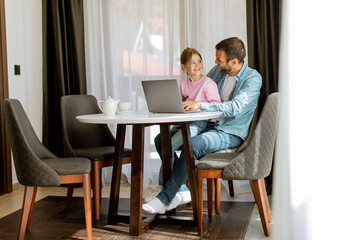 Father and daughter using laptop computer together