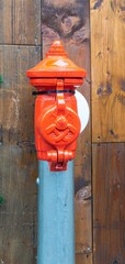 Red hydrant in city of Copenhagen with wooden background