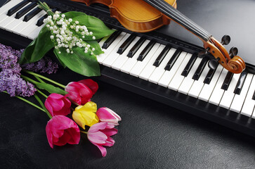 Synthesizer keyboard, violin and bouquet of lilies of the valley and tulips. 