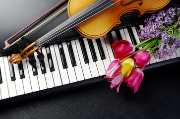 Synthesizer keyboard, violin and a bouquet of flowers.
