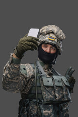 Shot of glad serviceman from ukraine dressed in protective uniform taking selfie. Information warfare.