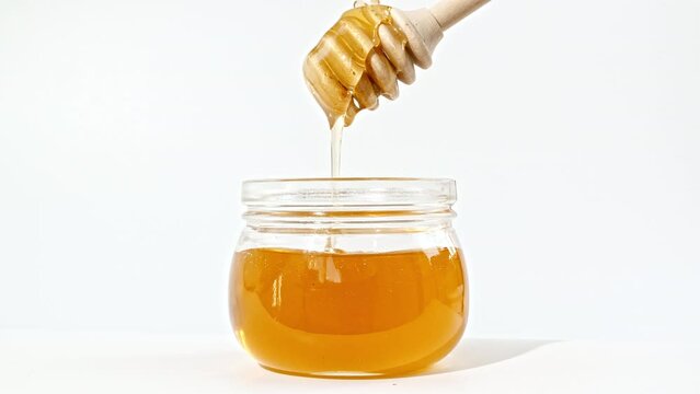 Honey Dripping, Pouring from Special Honey Spoon in Glass Bowl. Honey Dripping Isolated on White Background. Healthy Food Concept. High quality 4k footage