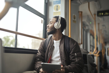 young man listens to music on a tram