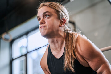 Fototapeta premium Woman with achondroplasia disorder training with barbel at the loft gym