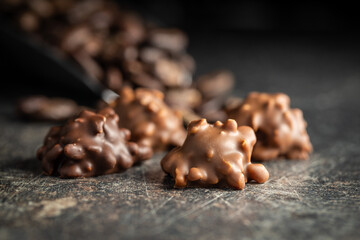 Chocolate truffles. Sweet pralines on black table.