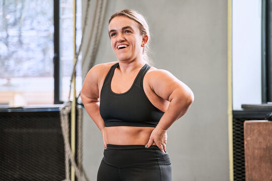 Cheerful woman with autosomal disorder relaxing after workout at the gym