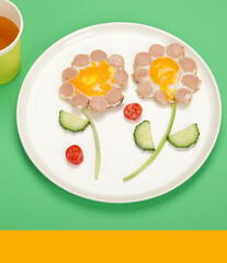 Sunny-side-up eggs with sausage for kids on colourfull background.