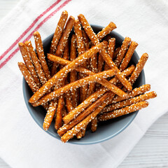 Baked Pretzel Sesame Sticks in a Bowl, top view. Flat lay, overhead, from above.