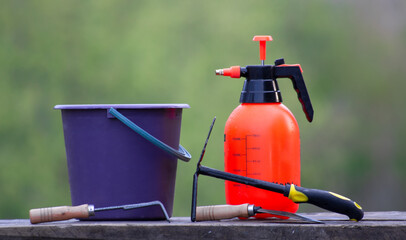 Garden tools on wooden boards. Bucket sprayer and garden tools.