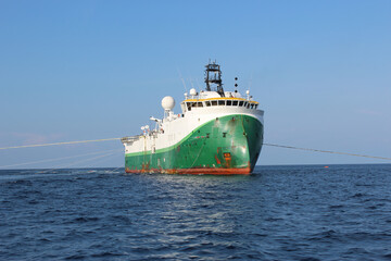 Seismic survey vessel moving ahead with all towed in sea equipment deployed. Oil and gas...
