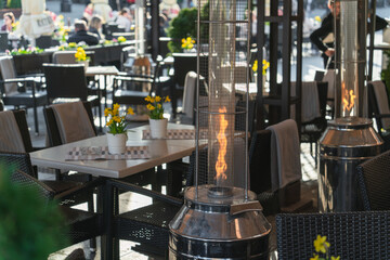 The flame of a gas burner inside glass tubes in an open-air restaurant in the evening twilight...