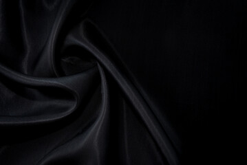 Part of the dark fabric texture of the fabric for the background and decoration of the work of art, a beautiful crumpled pattern of silk or linen. A crumpled piece of cloth