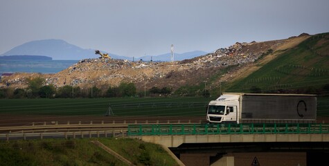 degradation of the landscape by a consumptive way of life in connection with a landfill and a truck