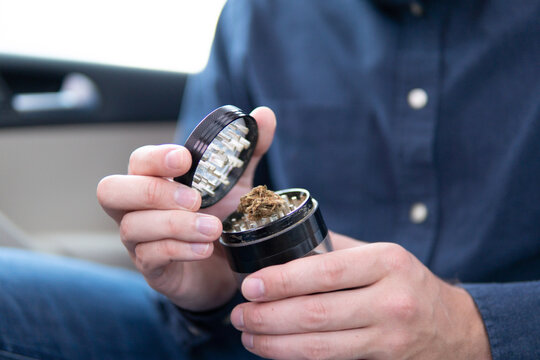joint packet of weed on a car background close up marijuana joint in hand bud flowers