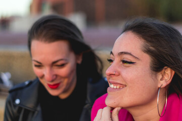 Couple of lesbian girls, one with a purple shirt and the other with black clothes and red lips. Concept: LGBT