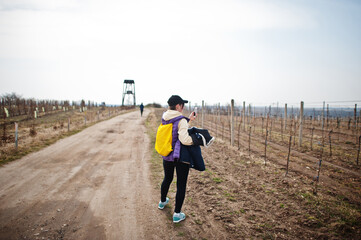 Woman tourist making photo on phone of vineyards.