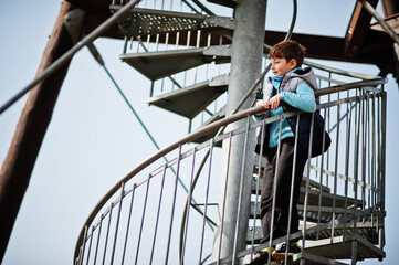 Boy stand at spiral staircase on observation tower.