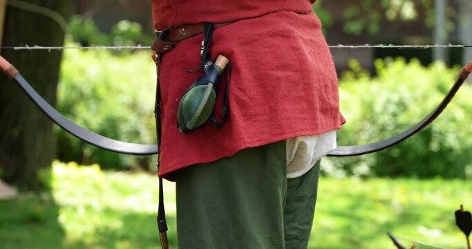 an outdoor event where a boy gives a token for shooting from a bow and arrow