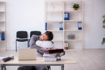 Young male employee in oversleeping concept
