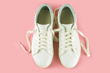 Pair of white sneakers on pink background. Unisex shoes, stylish white sneakers. Top view, flat lay, mockup with copy space for text