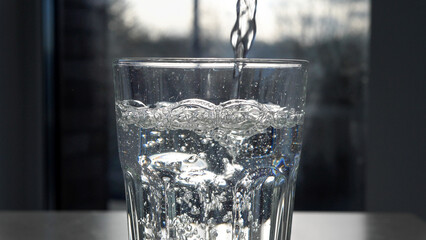 Pouring water into a clear glass