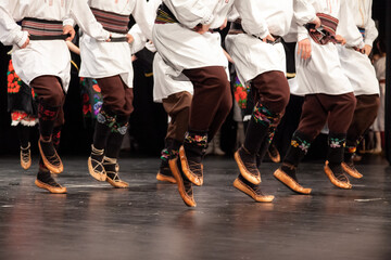 Serbian tradition dancers playing on annual concert. Folk Dancers from Serbia on the stage. Serbian folklore.
