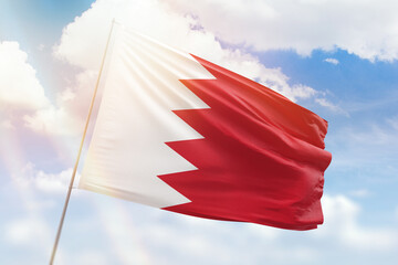 Sunny blue sky and a flagpole with the flag of bahrain