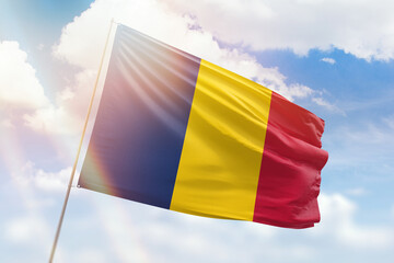 Sunny blue sky and a flagpole with the flag of chad