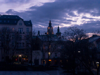 Naklejka premium Twilight colours of night Przemysl at Poland at Wladycze street. View is from museum of bells and tobacco pipes to the lights of bell tower and clock near Roman Catholic archicathedra in the Gothic 