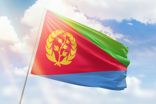 Sunny blue sky and a flagpole with the flag of eritrea
