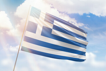 Obraz premium Sunny blue sky and a flagpole with the flag of greece