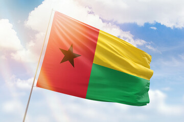 Sunny blue sky and a flagpole with the flag of guinea bissau